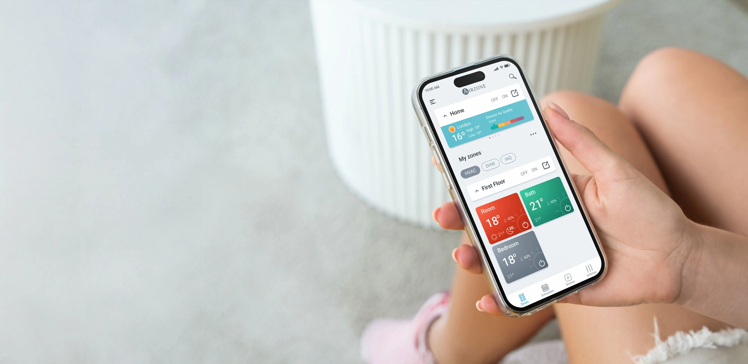 Person holding a smartphone with the Airzone Cloud app open, showing the home screen.
Person holding a smartphone with the Airzone Cloud app open, showing the home screen.