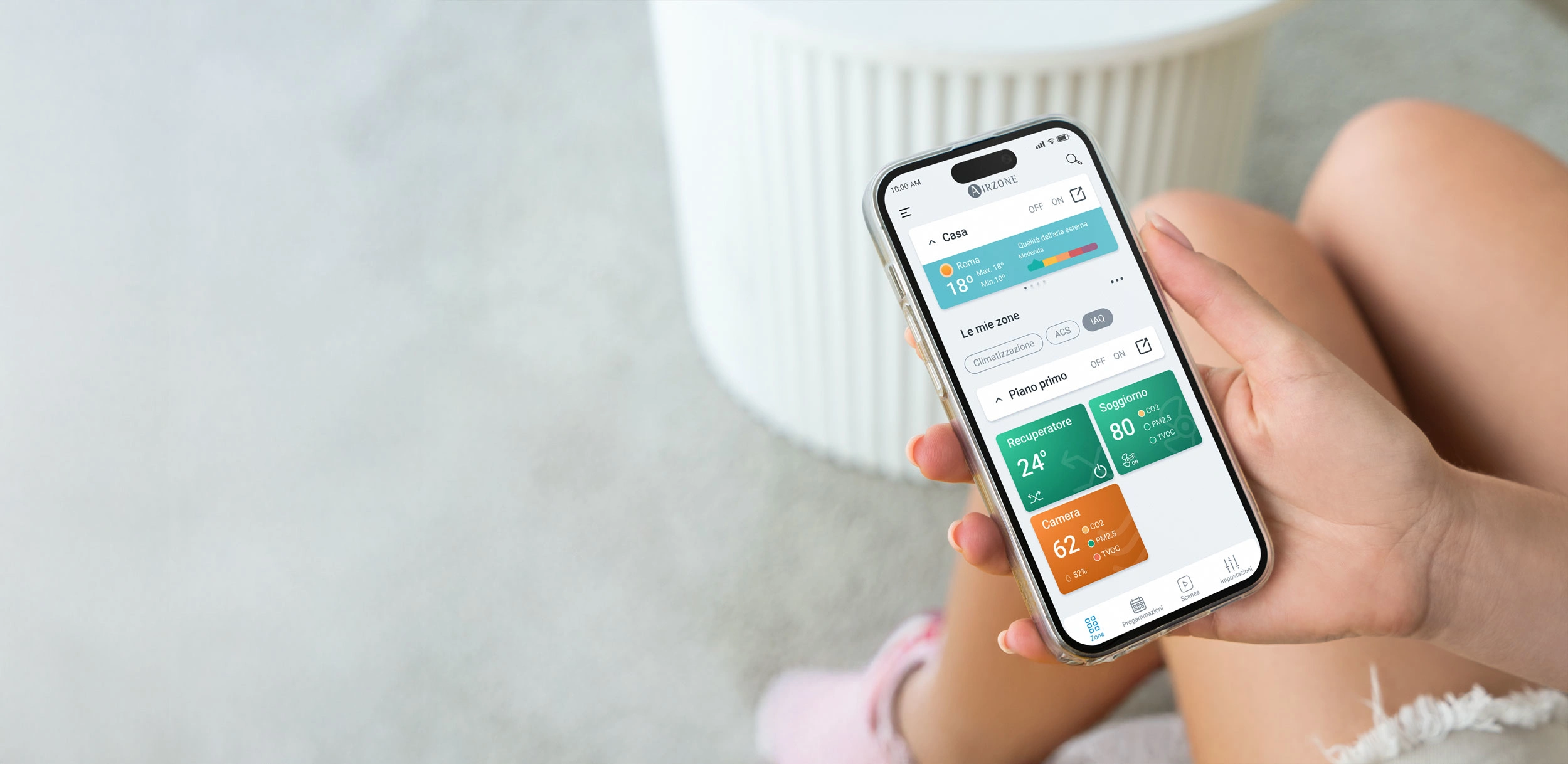 Persona che tiene in mano uno smartphone con l’app Airzone Cloud aperta, mostrando la schermata iniziale.