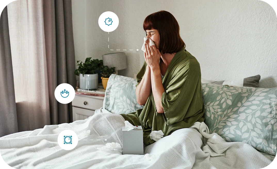 Woman blowing her nose in bed, illustrating the effects of poor air quality Woman blowing her nose in bed, illustrating the effects of poor air quality