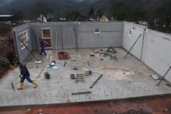 Over half of concrete walls are set on the concrete base of the house.