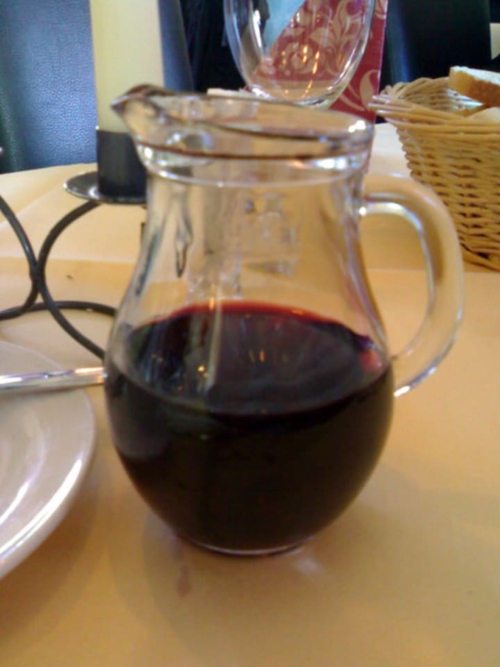 A small jug with red wine.