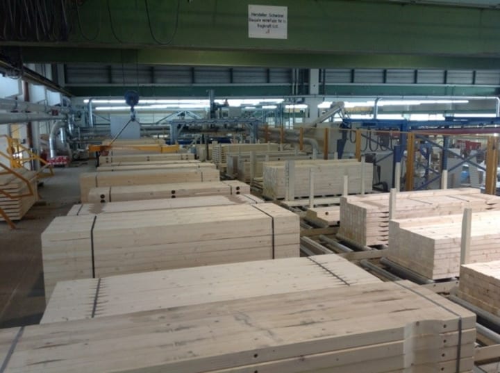 many piles of various sizes of plank inside a building