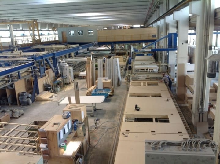 a view of a factory with a 3 metre wide conveyor belt with the walls of a house lying on it