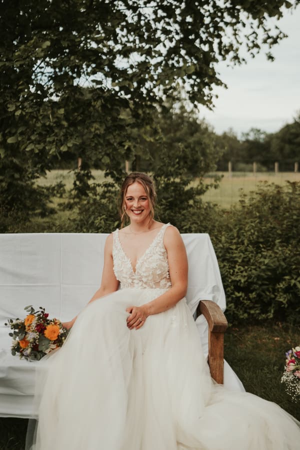 Braut mit Blumenstrauß auf Traubank während der Trauung in Hannover – Emotionale Hochzeitsfotografie von Alex Begopoulos