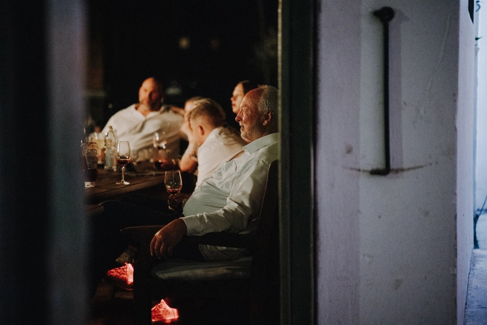 Brautvater genießt die Zeit mit einem Glas Wein – Entspannte Momente der Hochzeitsfeier am Abend