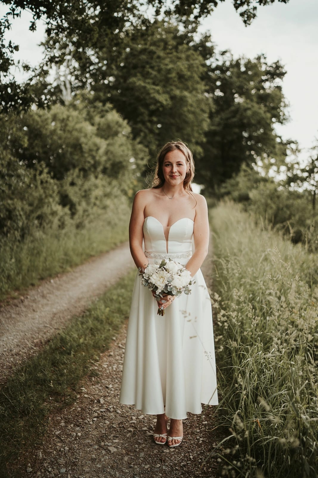 Braut-Portrait mit Brautstrauß am Feldweg – Elegante Hochzeitsfotos