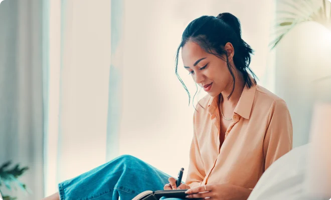 Woman creating a moving budget in a notebook