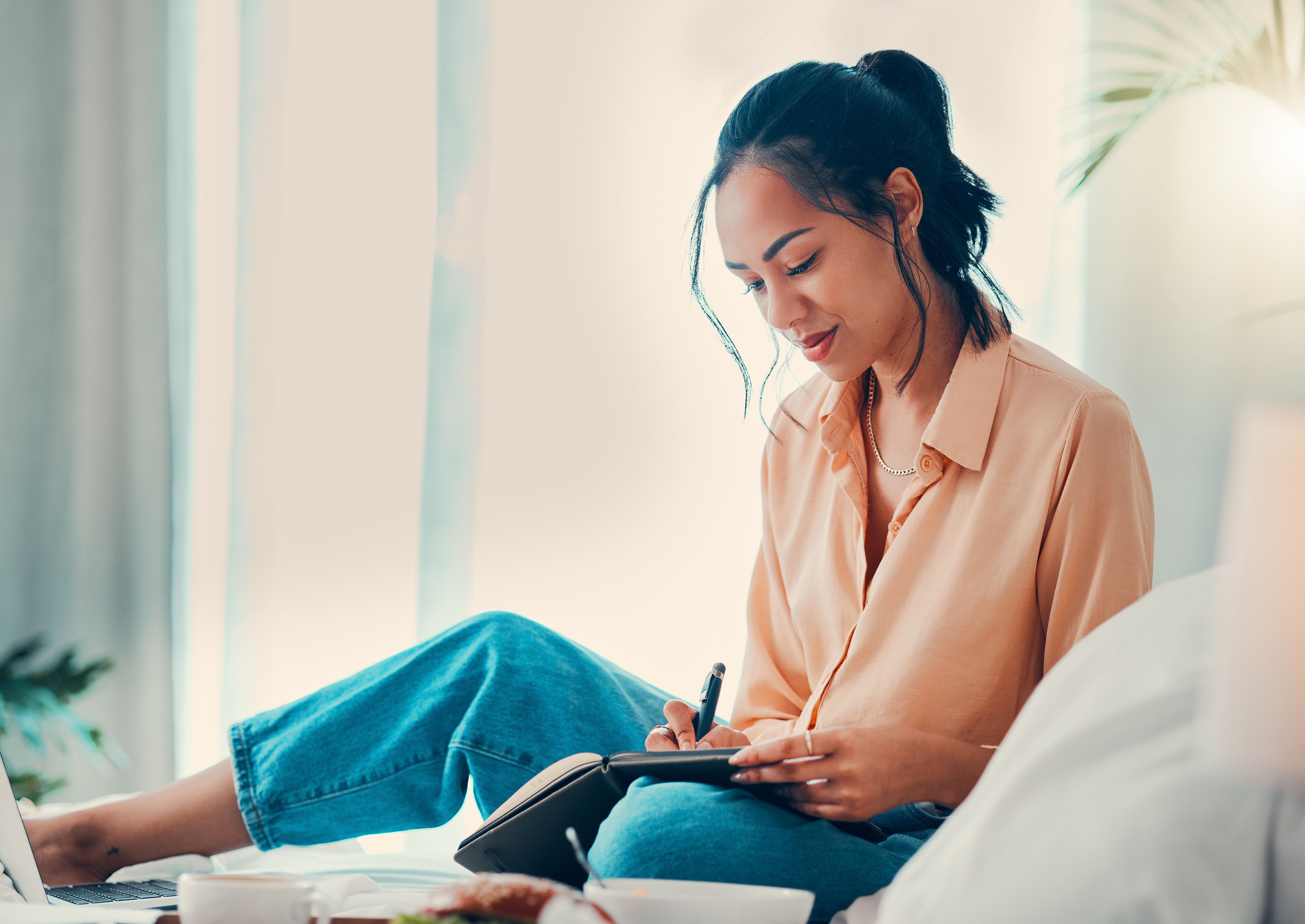 Woman creating a moving budget in a notebook