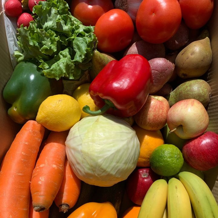 Le carton de légumes livré contenant bananes, carottes, poivrons, courgettes, pommes-de-terre, etc.