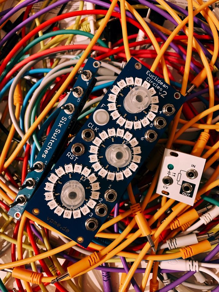 The following three modules are placed on a bed of patch cables: Eucidean Circles V3, Six Switches and Passive LPG