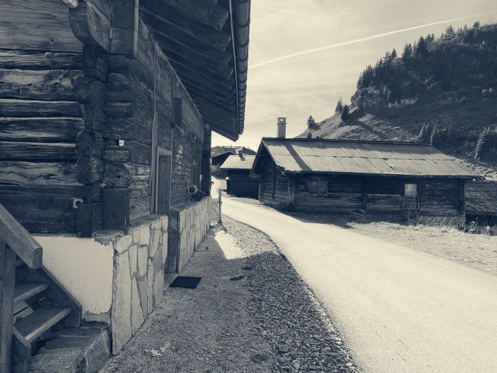 Black and white photo of châlets at Col de Bretaye. A path passes between the châlets