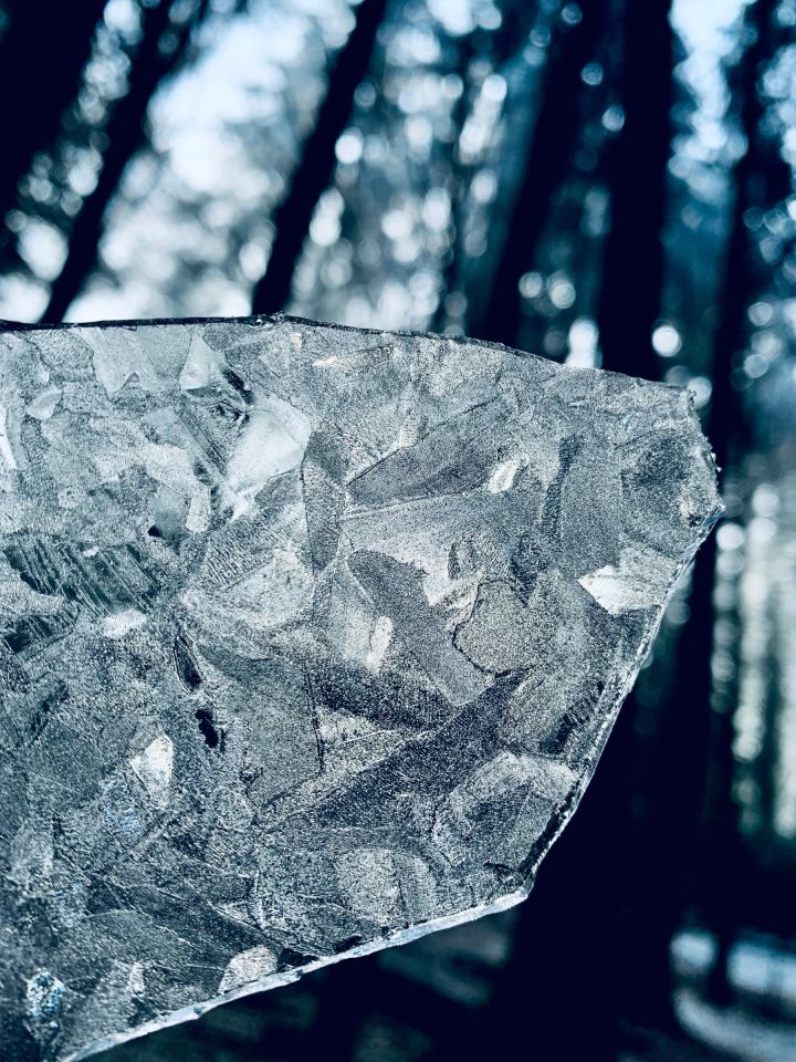 The sun shining through a broken piece of ice I hold in my hand. The ice looks like a stained glass window.