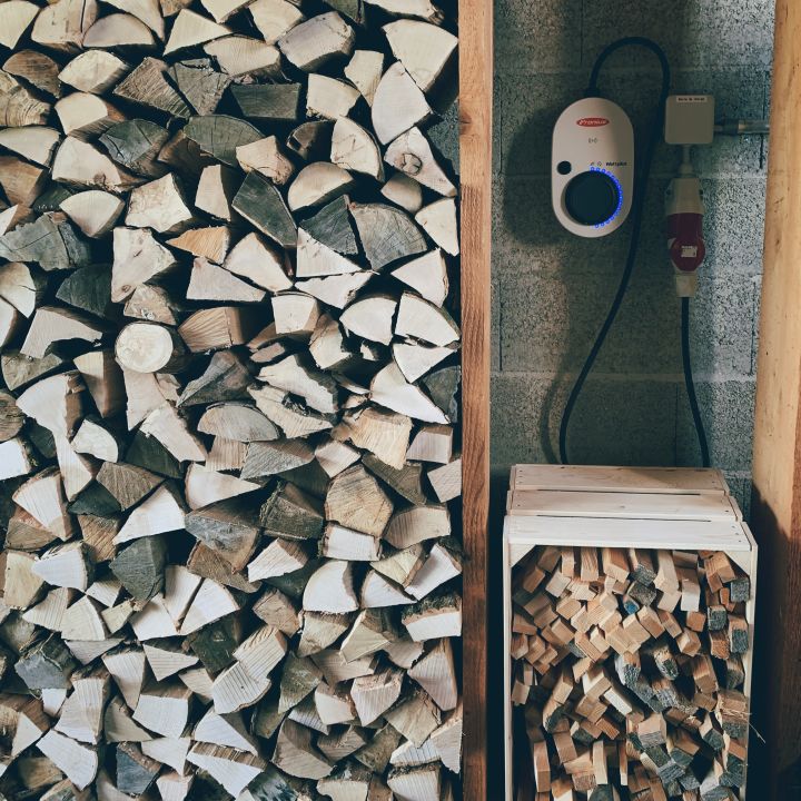 The wood is stacked next to our electric car charging station