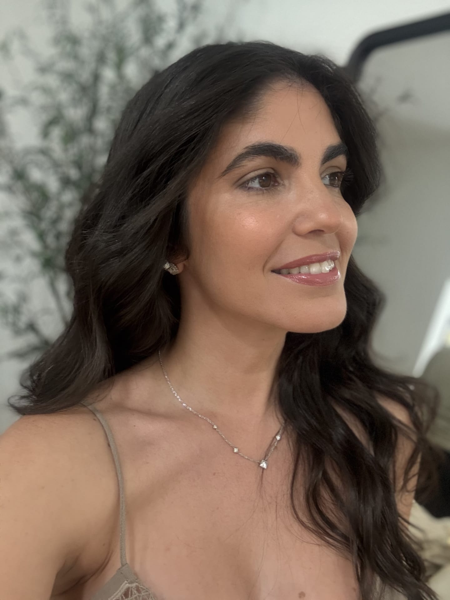 A Styling Betty client with a glossy blowout and soft natural glam, smiling in the Miami studio