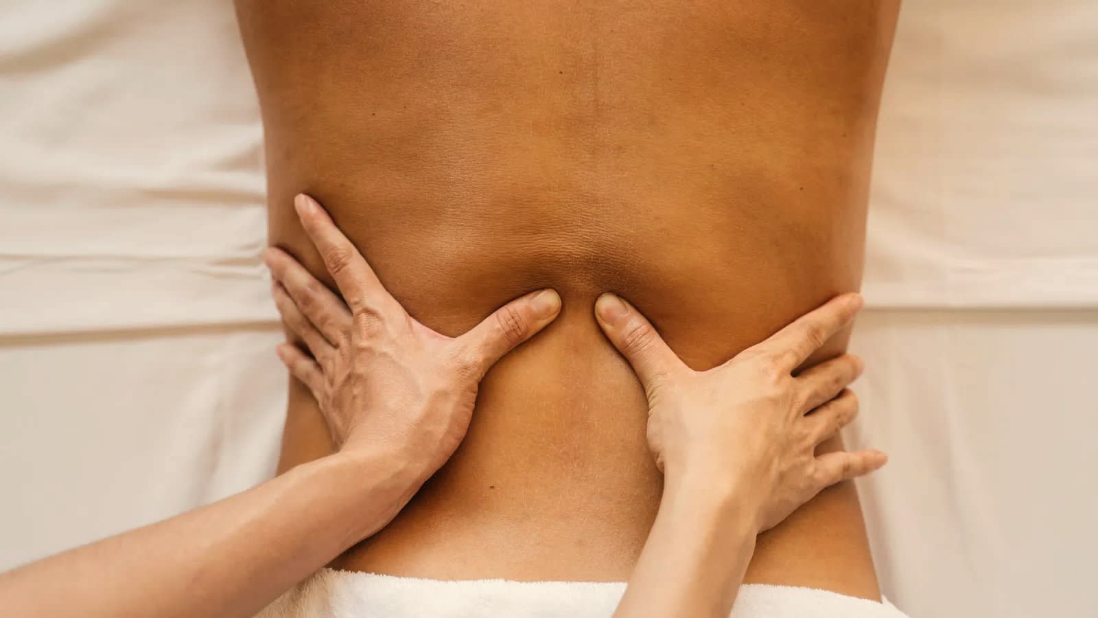 Hands pressing into the lower back during an 80–95 minute session.