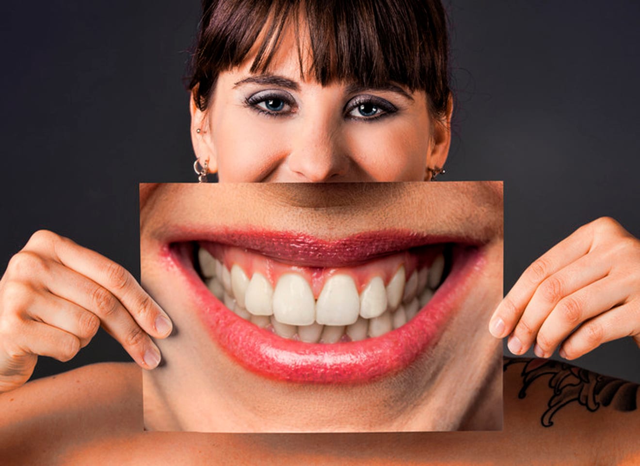 vrouw houd een foto van een grote mond met mooie tanden voor haar mond met link naar website tandarts Alberts in Kerkrade