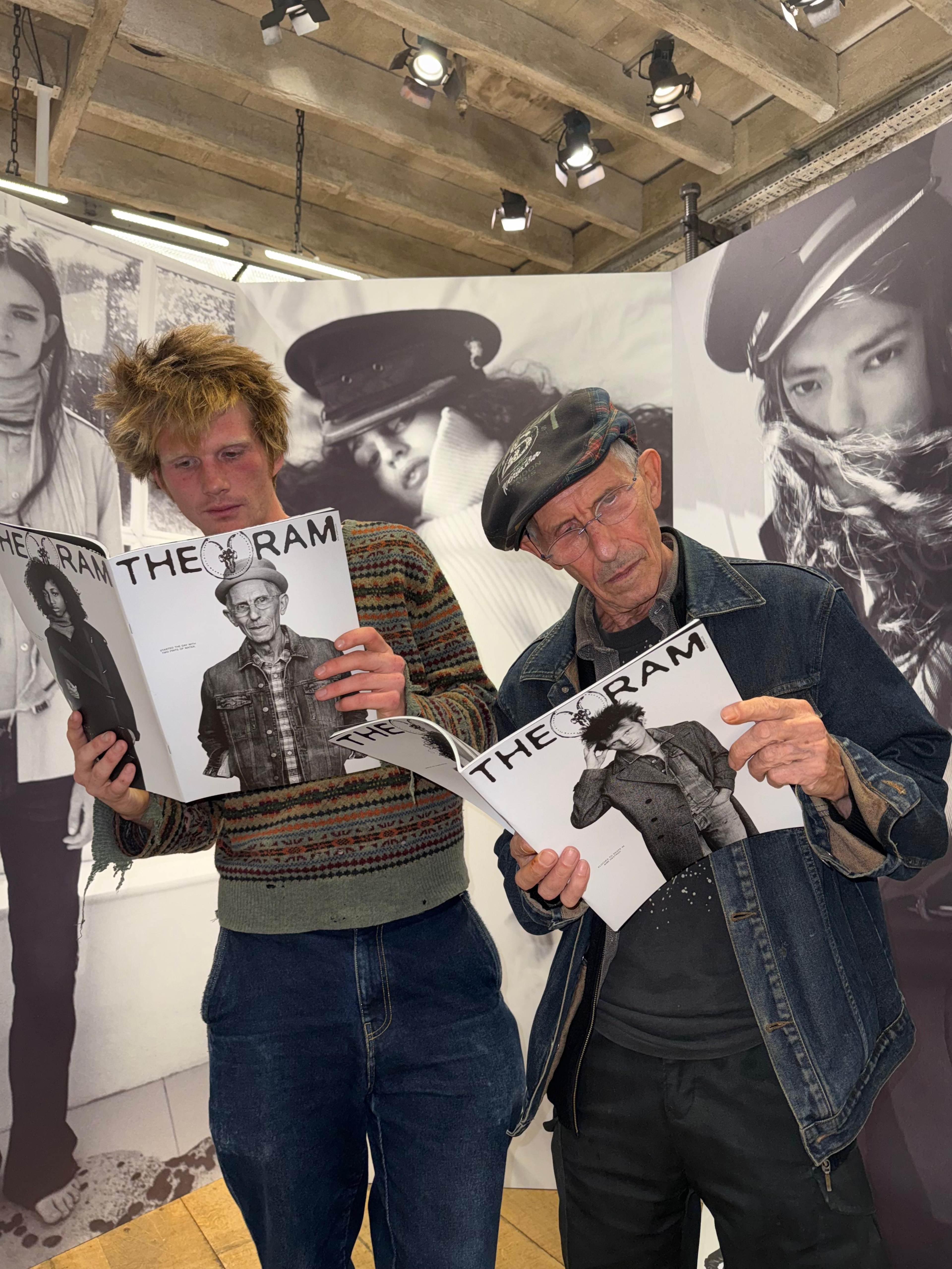 Two men leaning on the left while reading the THE RAM zines
