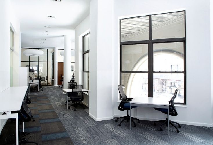 Opposing carpet patterns liven up the monochromatic scheme of this hallway while simultaneously creating the perception of two work zones (Civic Hall).