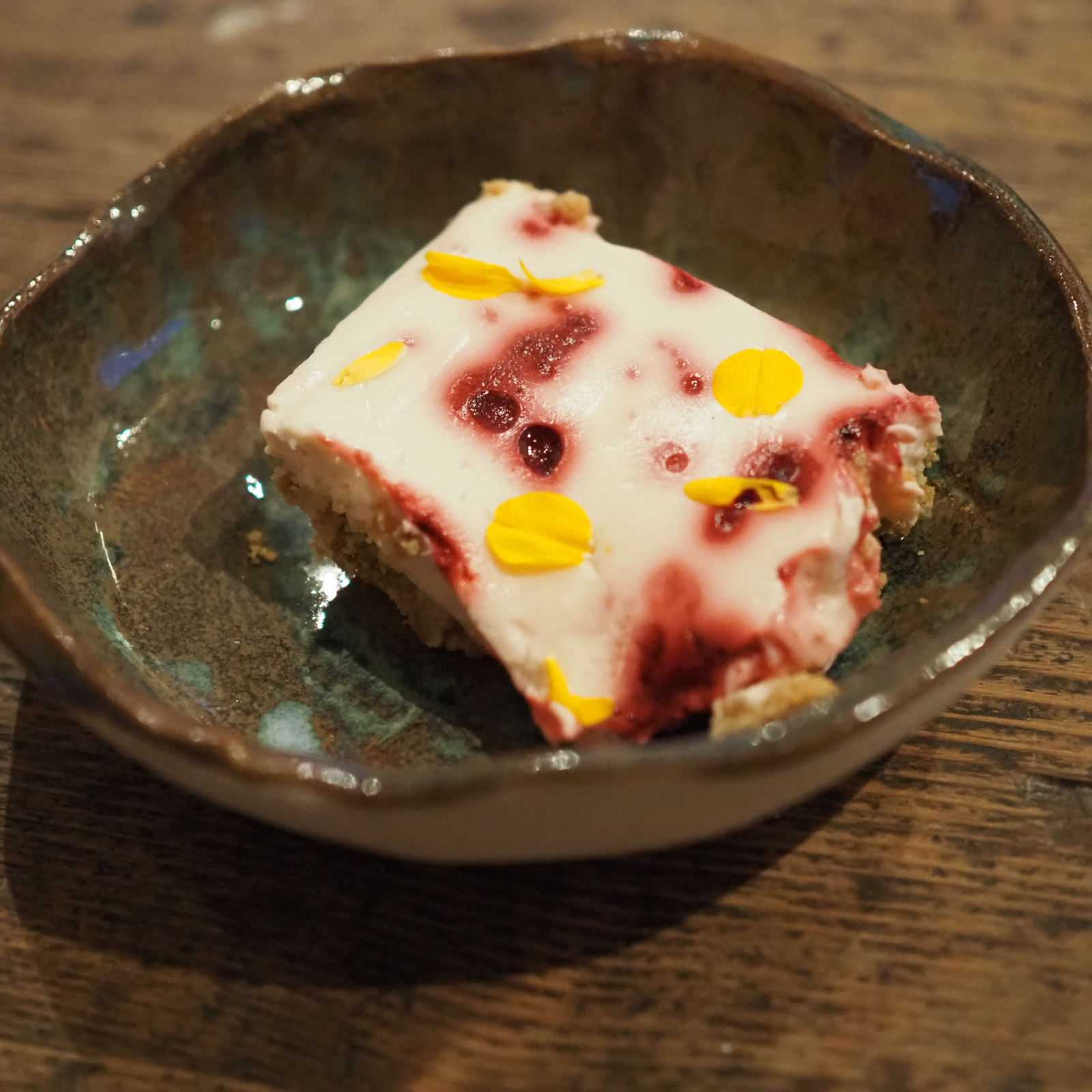 A photo showing a slice of cheese cake made using flowering red currant syrup.