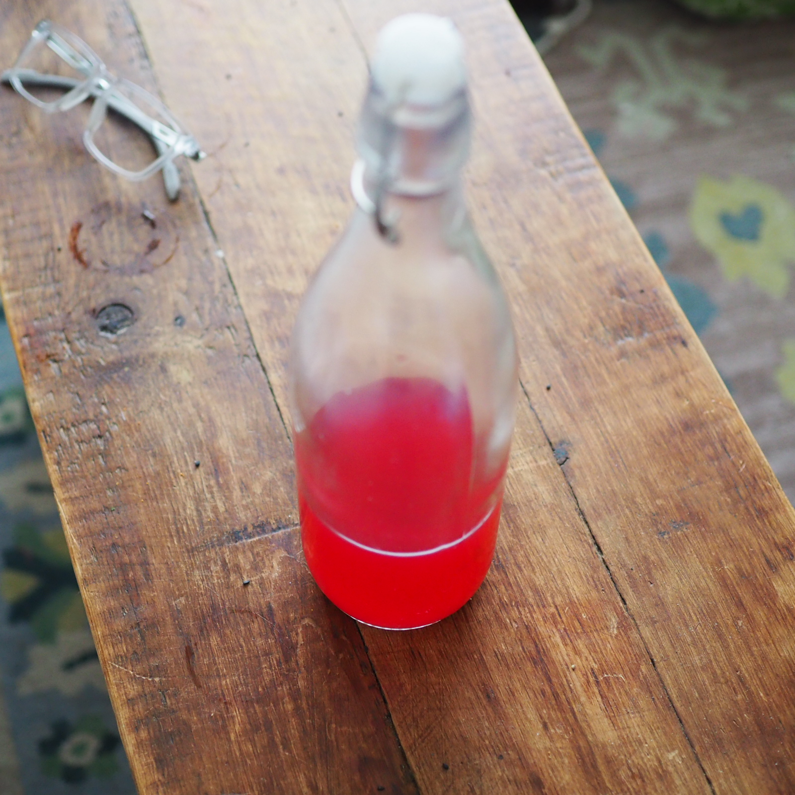 A glass bottle of flowering red currant syrup.