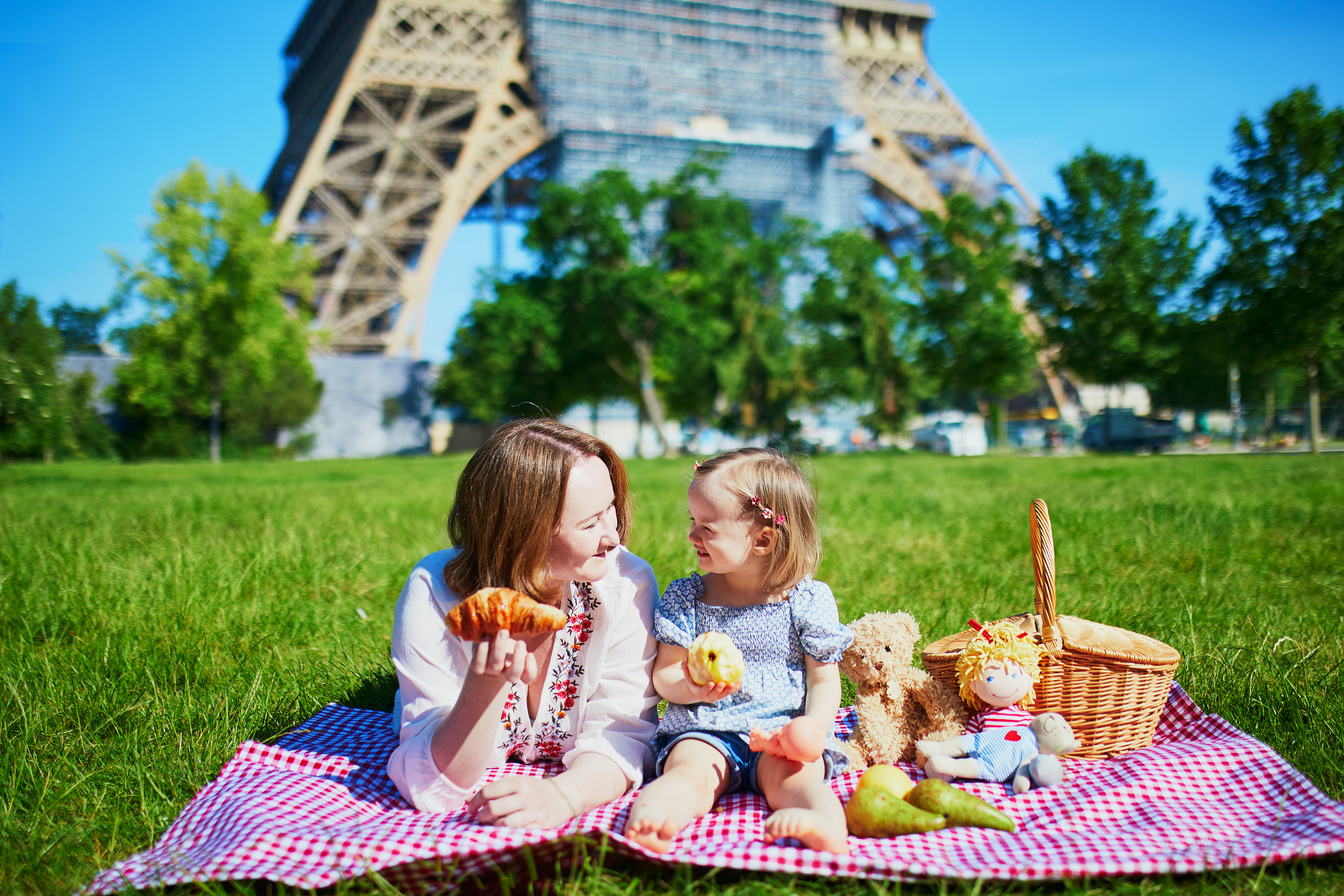 Mother and daughter enjoying a French-style picnic in front of the Eiffel Tower