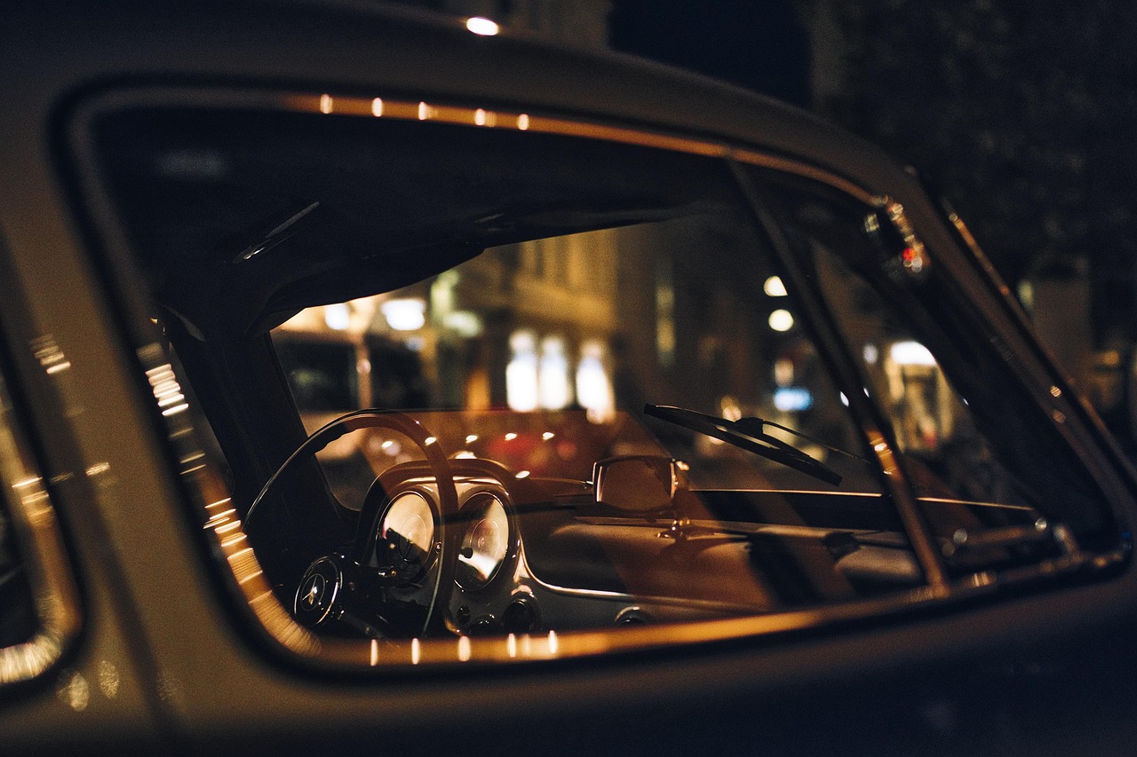 A camera shot through the passenger side door of a car at night.