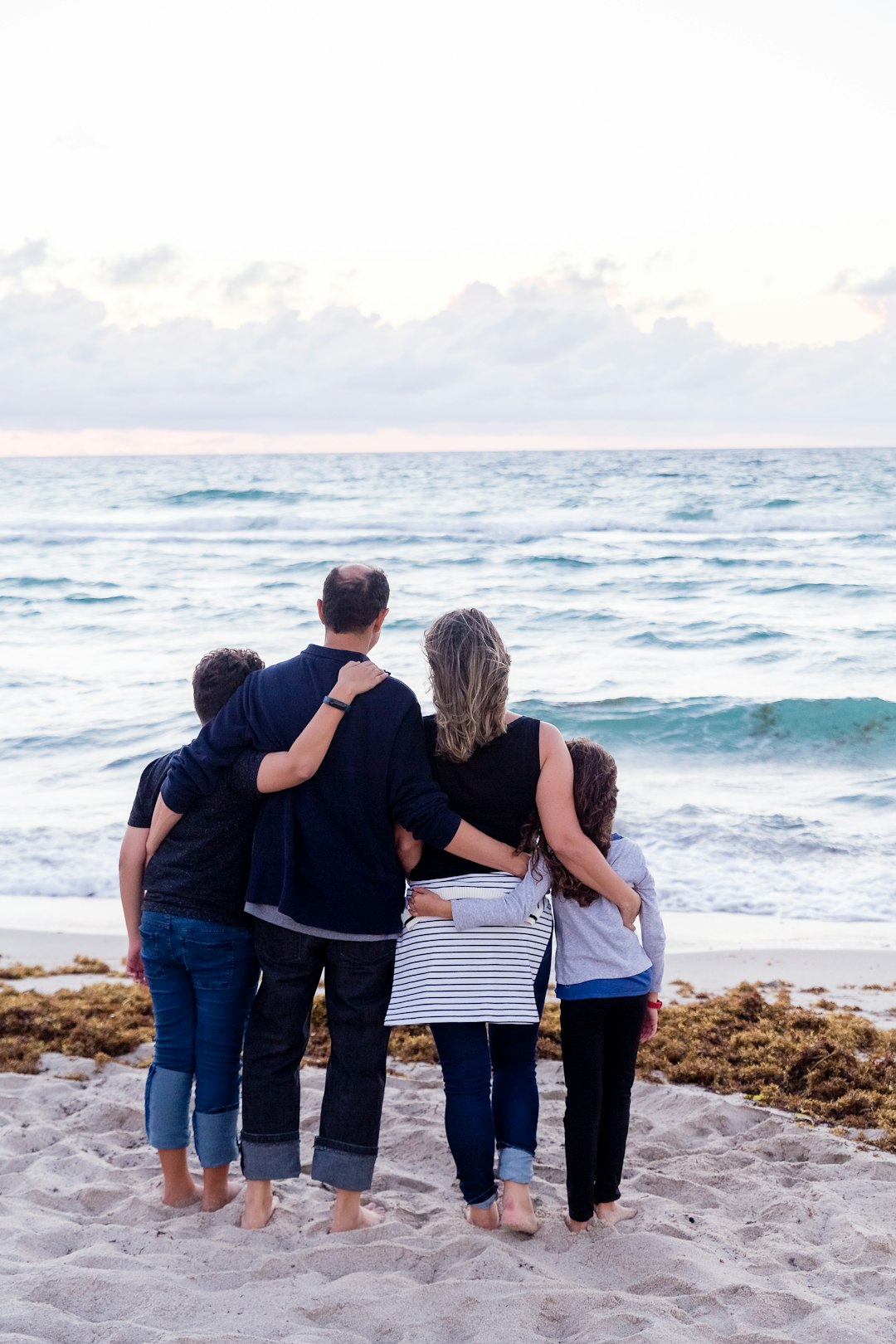 Family of four on a beach facing the sea