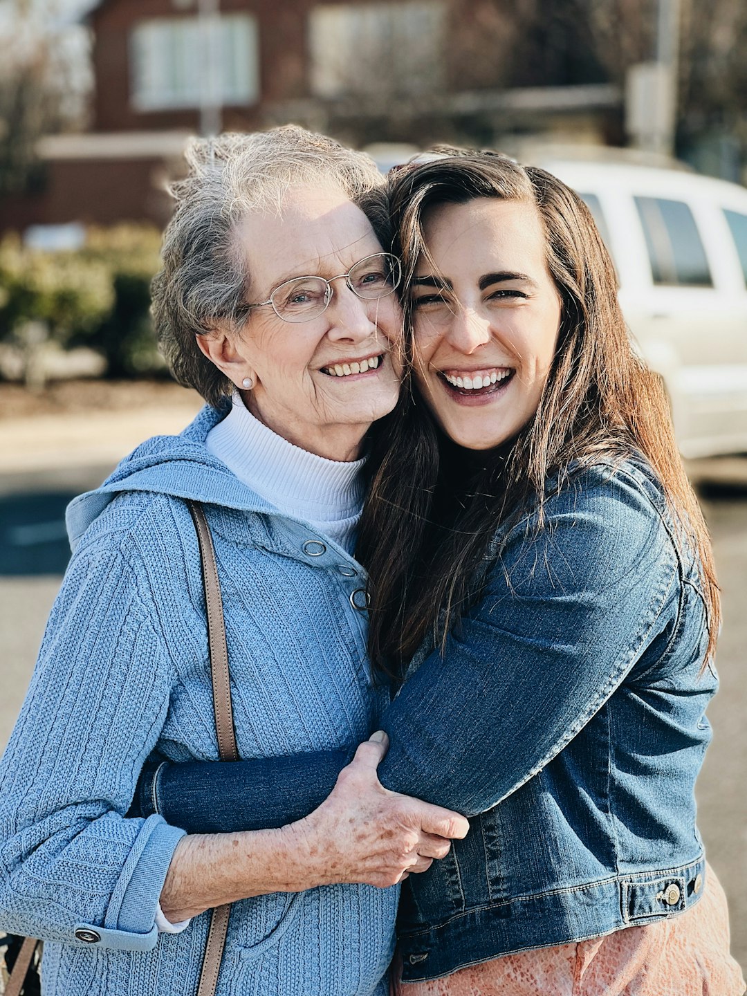 elderly woman and a young woman hugging each other and smiling