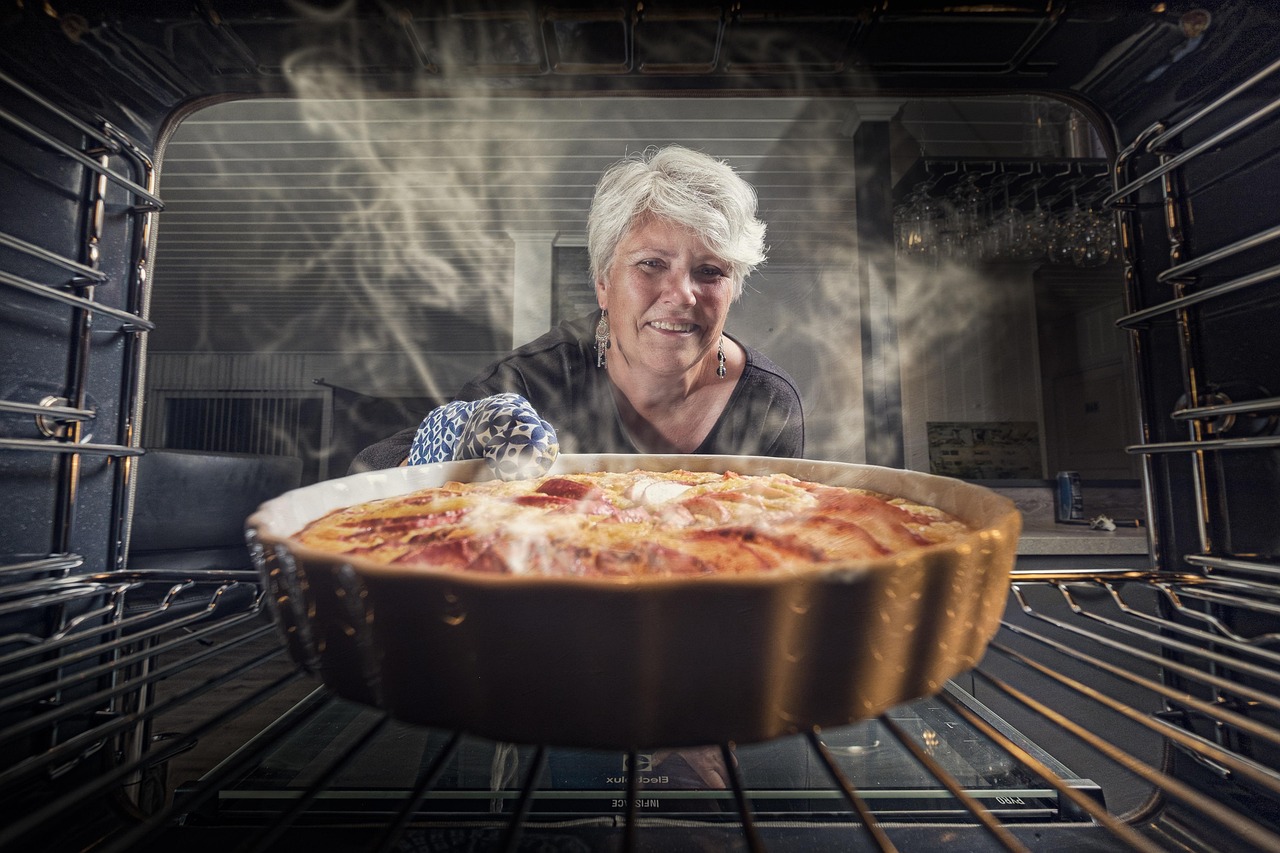 grandmother taking a casserole out of the oven. Perspective is from inside the oven.