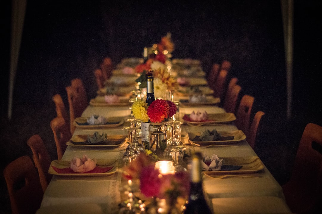 long luxury dinner table candle lit with many place settings