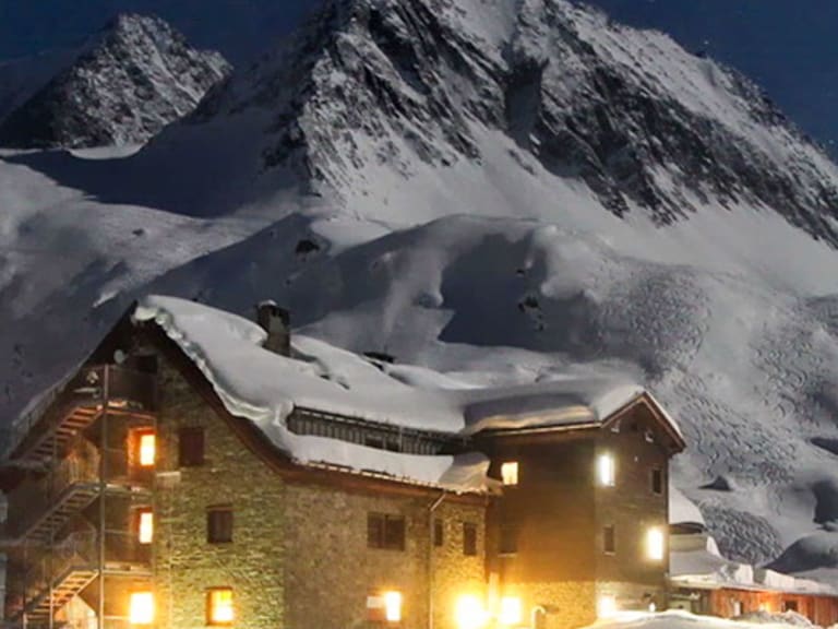 Die Franz-Senn-Hütte strahlt warmes Licht in die verschneite Winternacht der Stubaier Alpen.