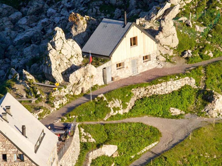Luftaufnahme der Pfälzerhütte zwischen Kalksteinfelsen und grünen Almwiesen im Rätikon.