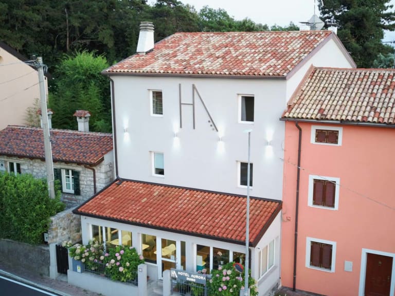Luftaufnahme zeigt die mediterrane Architektur des Hotel Aurora Duino mit roten Dächern.