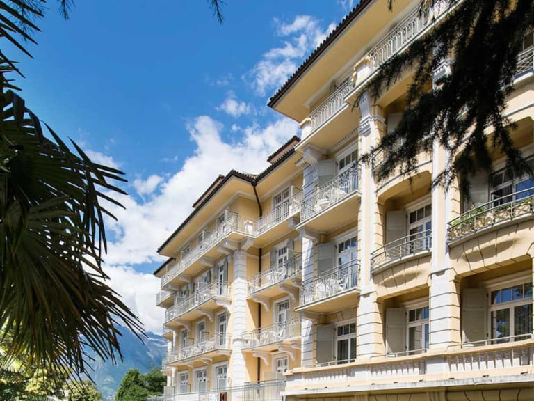 Außenansicht vom Hotel Kolping Meran mit klassischer Jugendstilfassade und Säulen im Erdgeschoss.