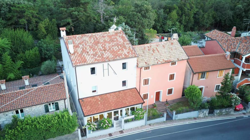 Drohnenaufnahme der bunten Gebäude und Gärten rund um das Hotel Aurora Duino.
