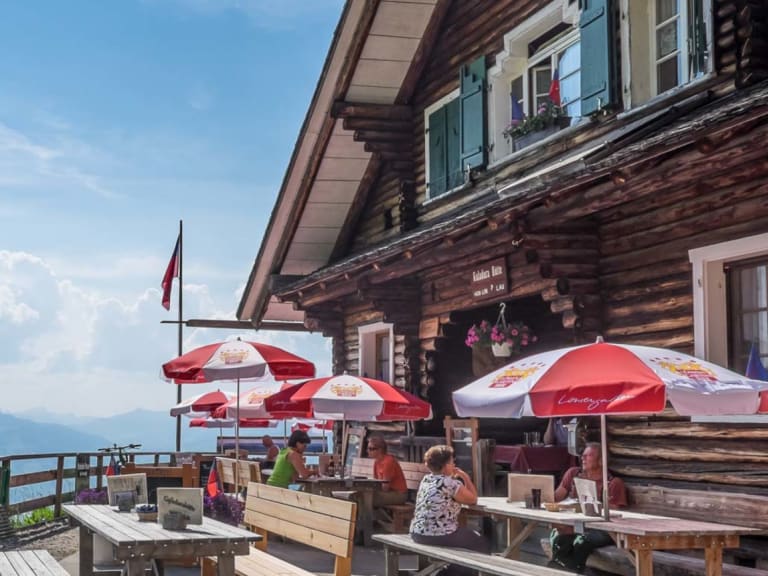 Bergwanderer auf der Terrasse der Gafadurahütte mit Panoramablick auf die Rätikon-Gipfel.