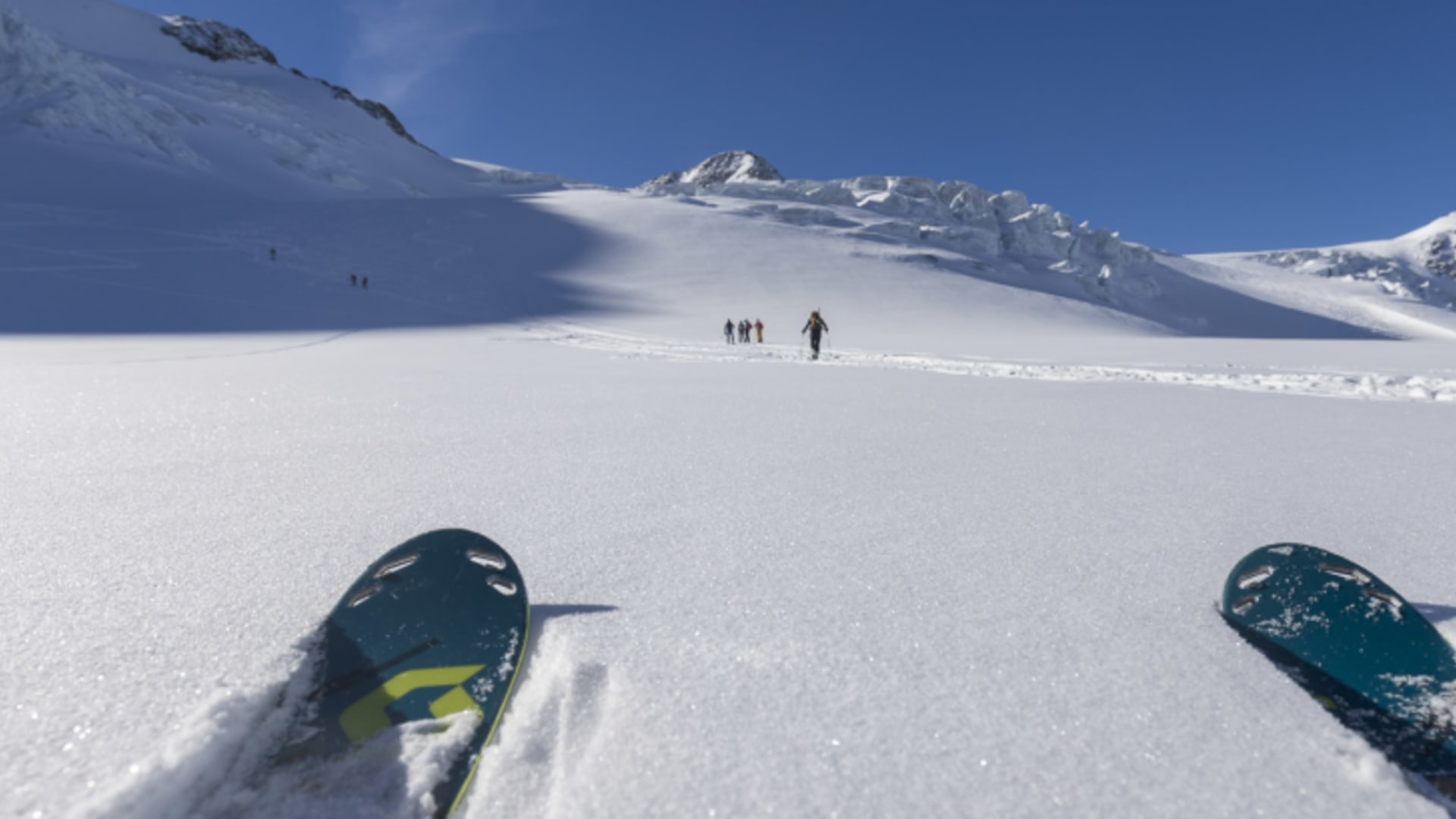 Skitour auf dem Wildspitze-Gletscher: Skitourengeher steigen über ein flaches Schneeplateau auf.