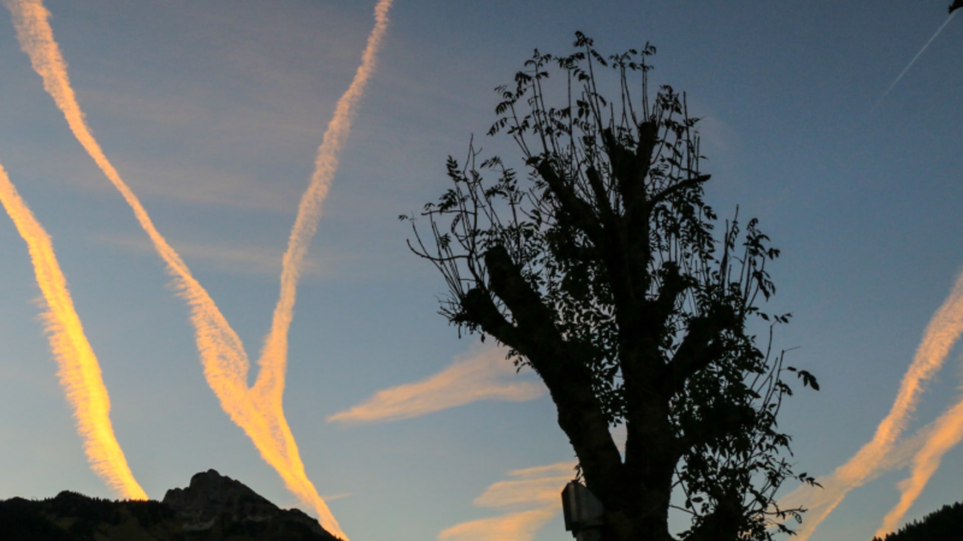 Bergwanderung im Tannheimer Tal: Abendhimmel mit Kondensstreifen, Mondsichel und Bergsilhouetten im Allgäu.