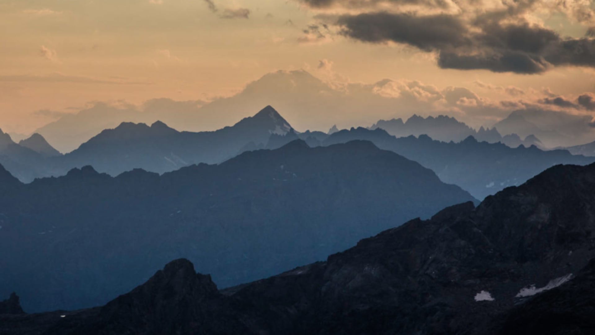 Abendpanorama der Walliser Alpen mit gestaffelten Bergketten und warmem Abendhimmel bei Zermatt.