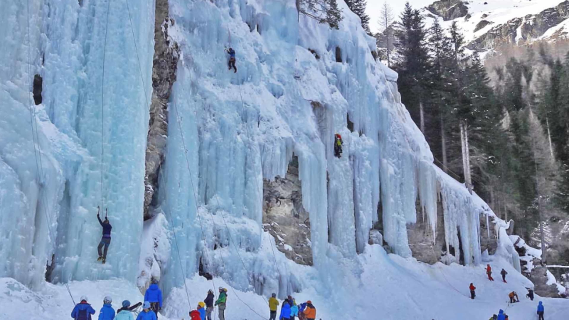 Eiskletterer an großflächigen Eisfällen im Eiskletterpark Osttirol mit Seilen und Steigeisen.