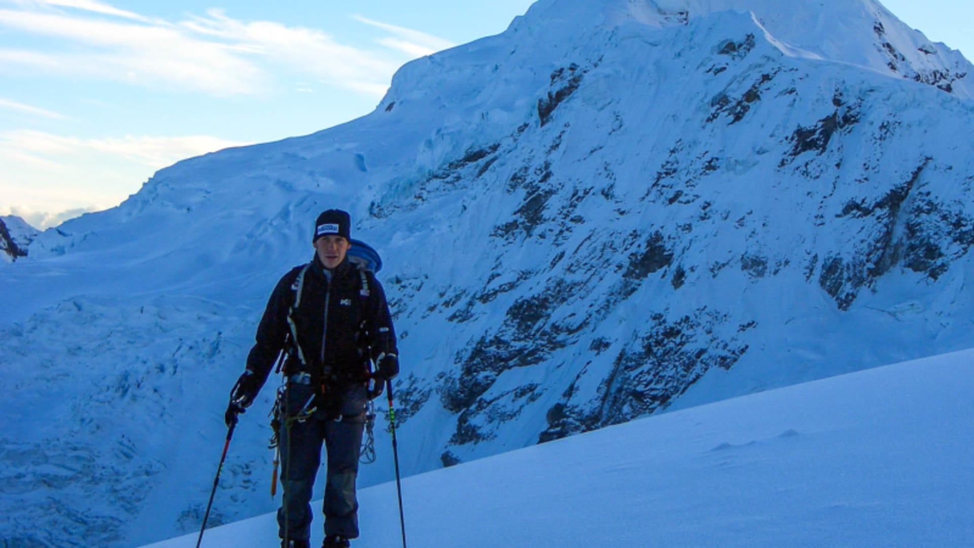 Expedition Alpamayo: Bergsteiger mit Steigeisen, Klettergurt und Teleskopstöcken akklimatisiert auf schneebedecktem Steilhang