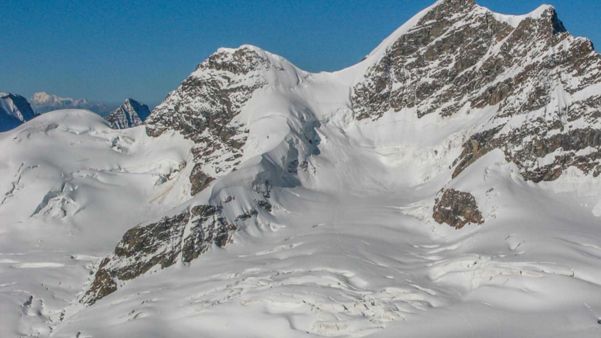 Hochtour ab Jungfraujoch: Panorama des Aletschgletschers mit pyramidenförmigem Gipfelmassiv, Firnplateau und Seilbahnstation
