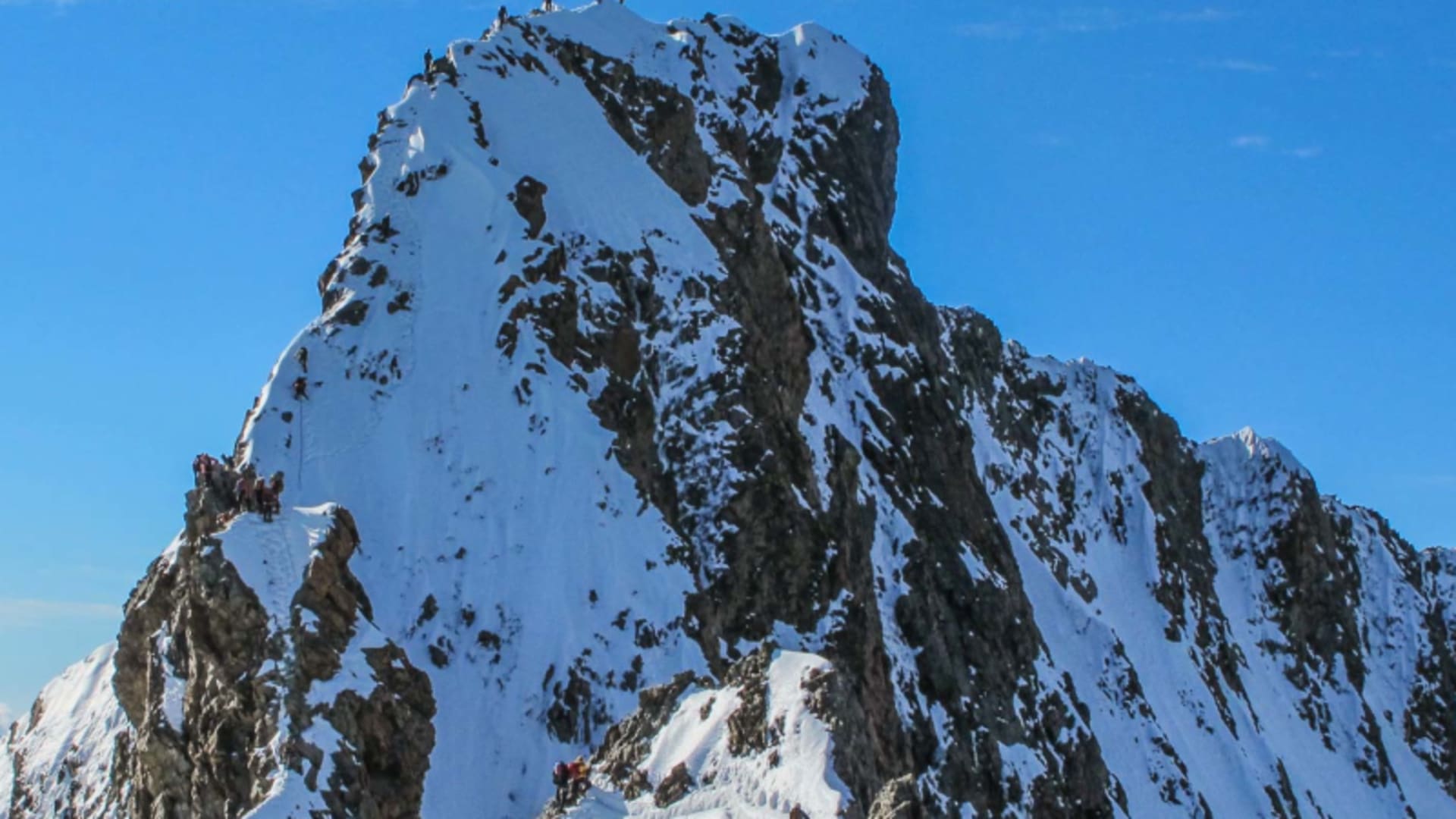 Hochtour am Bianco Grat: Bergsteigergruppen am Gipfelaufbau und Grat des Piz Bernina in den Bernina-Alpen.