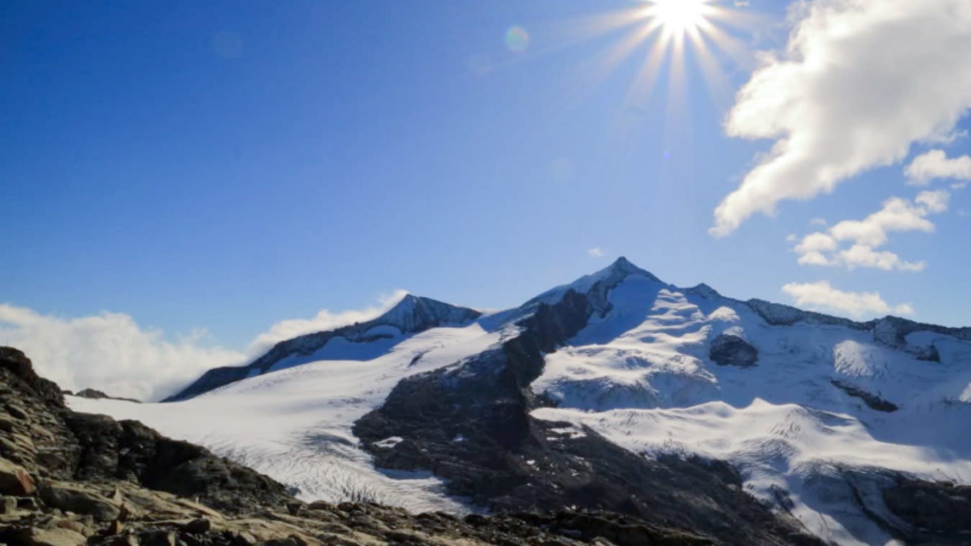 Hochtour in den Hohen Tauern: spitzer Gipfel mit Gletscher und Geröll im Vordergrund, klarer Sommerhimmel.