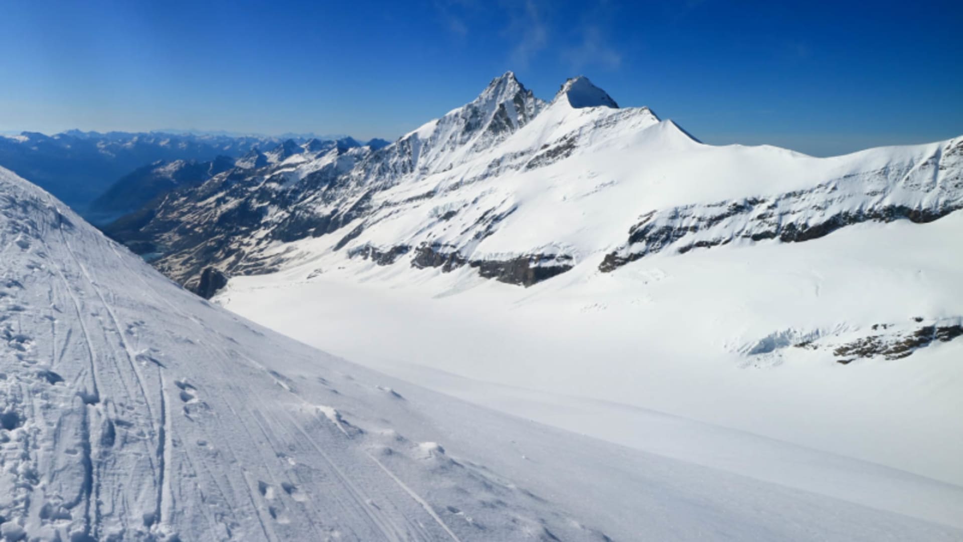 Hochtour Johannisberg: schneebedeckter Schneekamm mit Spuren im Schnee und Blick zum doppelgipfligen Großglockner.
