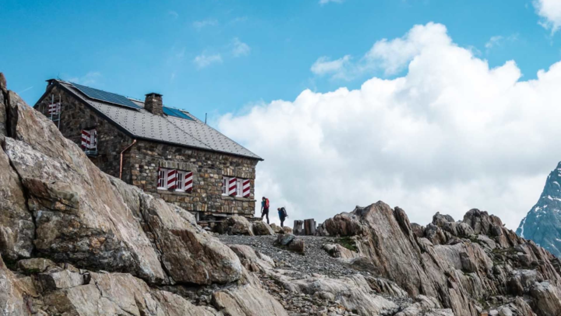 Zwei Bergsteiger vor der Tierberglihütte in der Schweiz, Stützpunkt im Aufbaukurs Hochtour auf felsigem Untergrund.
