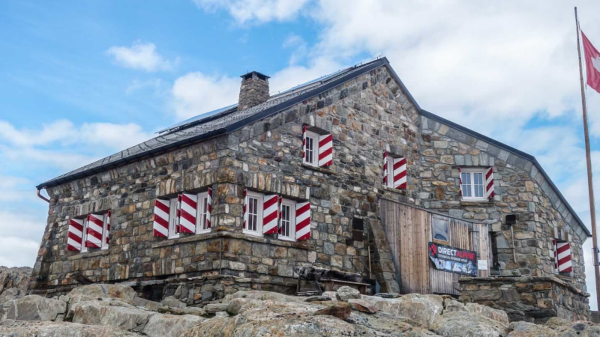 Tierberglihütte auf felsigem Granituntergrund mit Schweizer Flagge – Ausgangspunkt für Hochtour und Hochtourenkurs in den Alpen