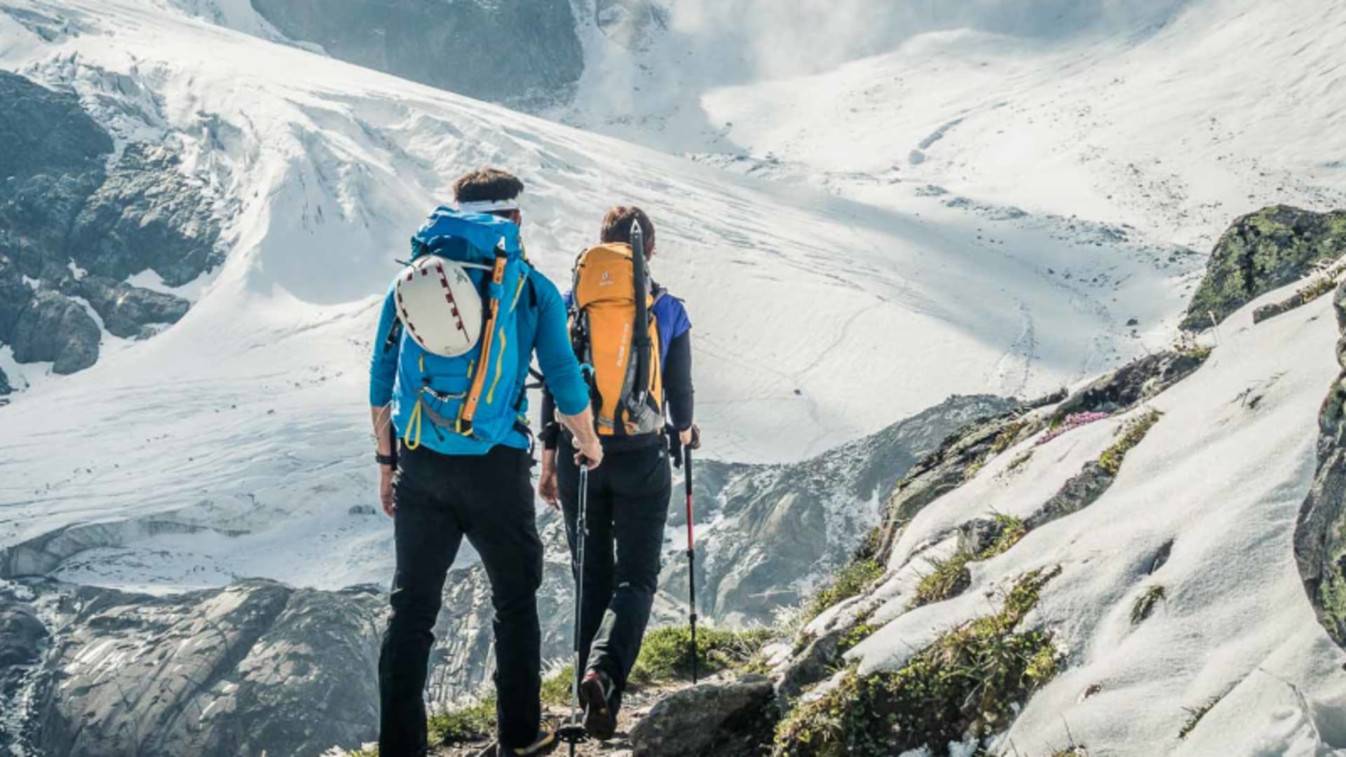 Zwei Bergsteiger gehen auf Felsweg zum Gletscher im Hochtourenkurs in den Ötztaler Alpen.