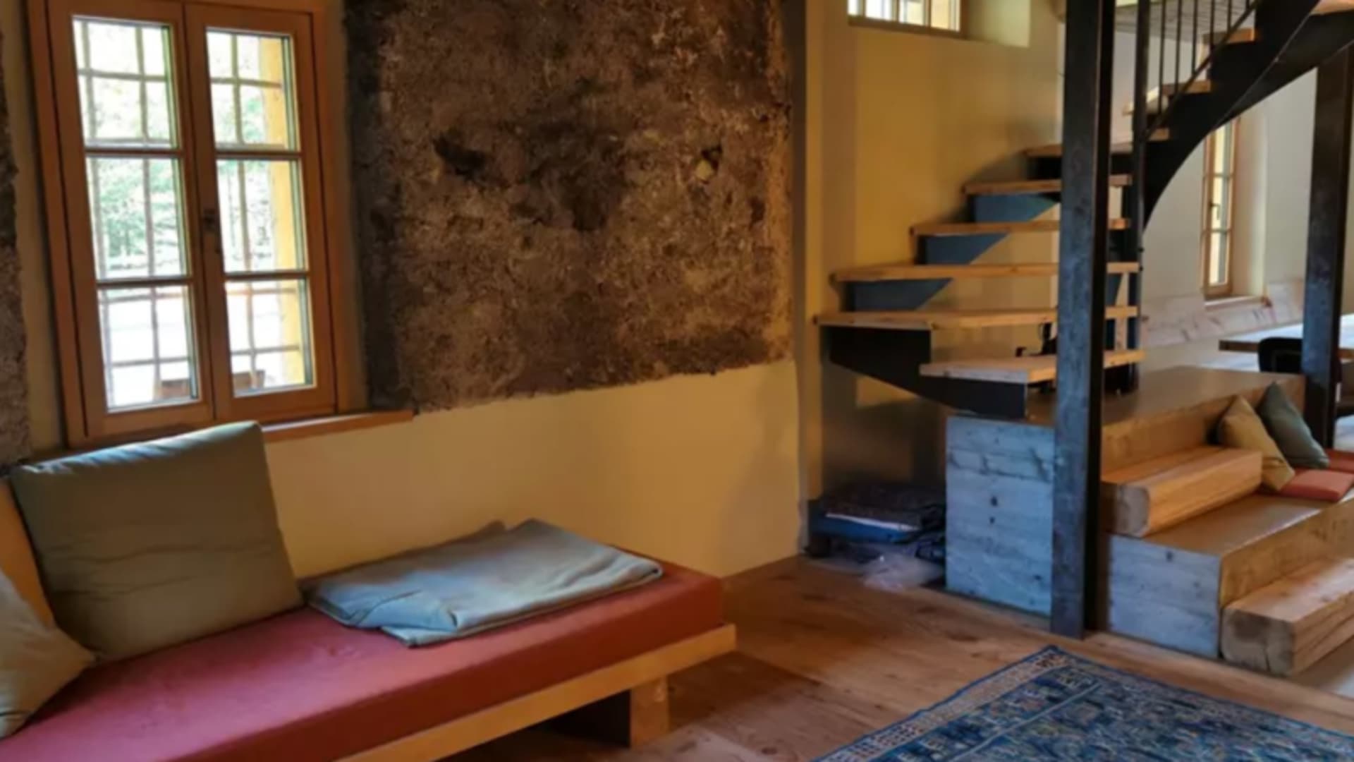 Innenraum der Unterkunft Anas 126 – Ausgangspunkt zum Klettern – mit freitragender Wendeltreppe aus Holz und Metall