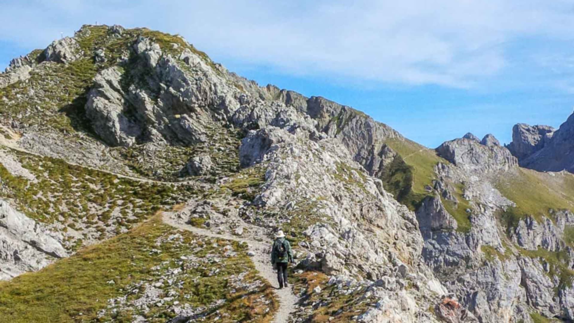 Klettersteiggeher auf dem Mittenwalder Höhenweg entlang eines felsigen Kalksteingrats im Karwendel.